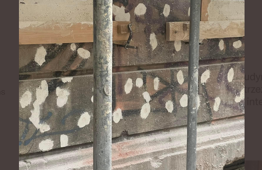 Ręce opadają! Robotnicy remontujący budynek zatynkowali ślady po kulach